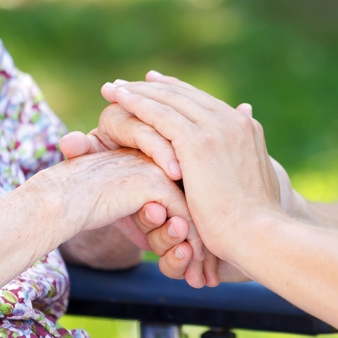 Hände die sich berühren Eine Hand legt sich über die andere. Als Symbol für Unterstützung und Fürsorge.